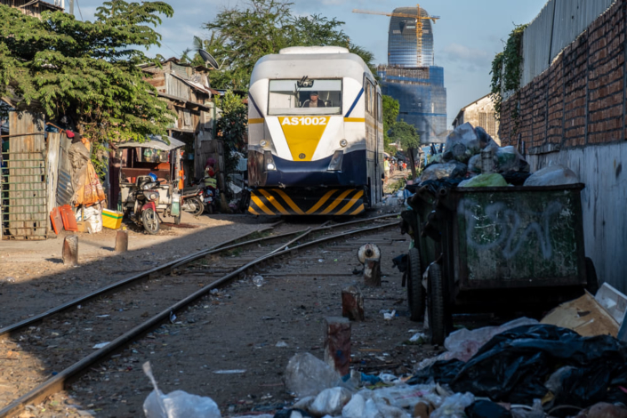 Un train traverse un bidonville au milieu de ordures