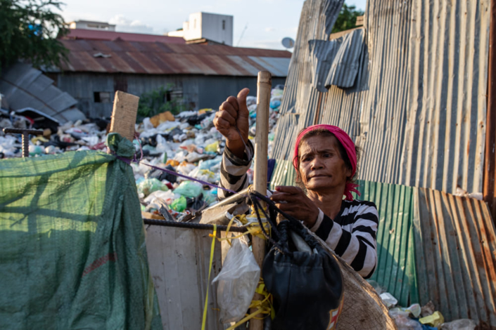 Une cambodgienne trie les ordures d'une décharge dans un bidonville de Phnom Penh