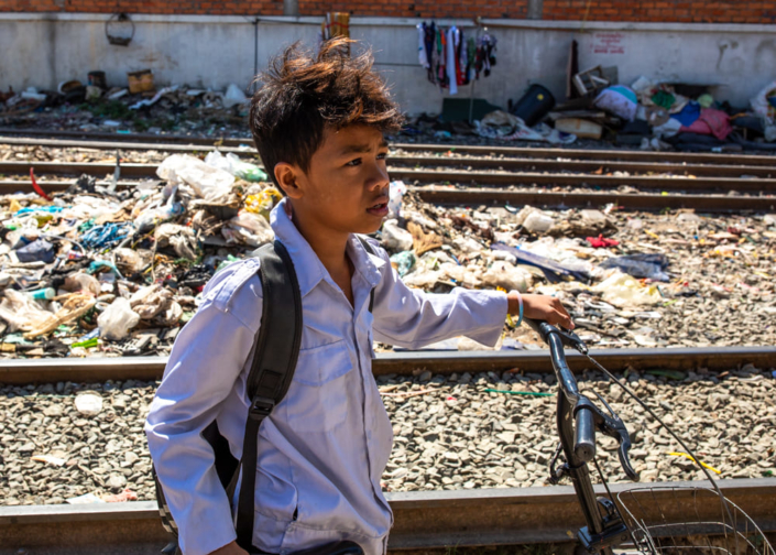 Portrait photographique d'un enfant à vélo au milieu des rails