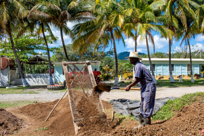 Un homme tamise du compost.