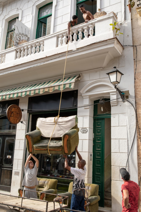 Un canapé est descendu au bout d'une corde dans une rue de la Havana Vieja