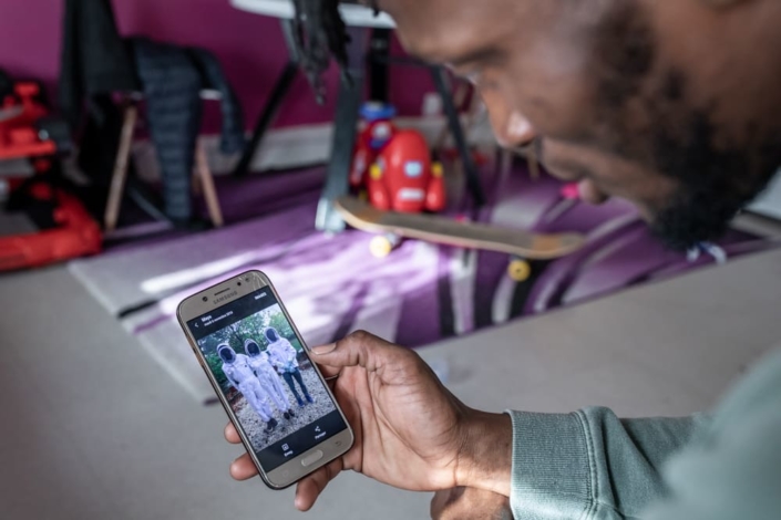 Un migrant regarde une photo d'apiculture sur un téléphone.