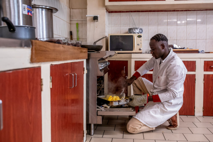 Un migrant prépare le repas pour un centre d'aide sociale