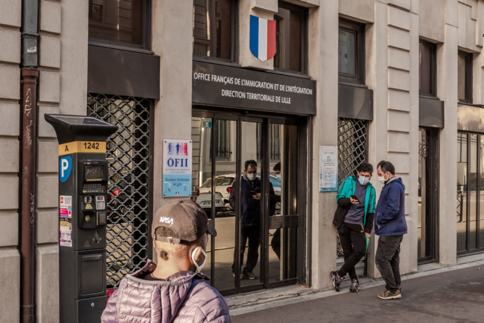 Hommes dans l'attente de faire les formalités au bureau de l'OFII