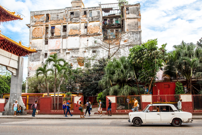 Photo d'un vieil immeuble de la Havane, une voiture passe
