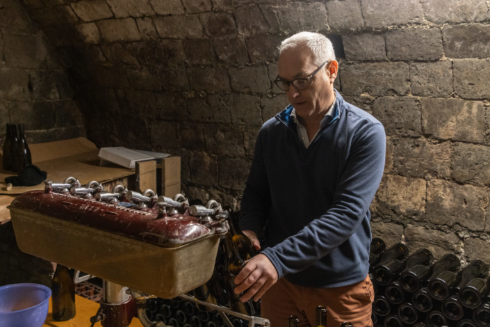 Un vigneron mets en bouteille le vin vieilli dans cette cave