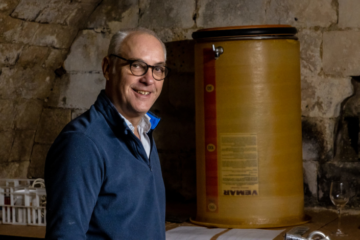 Portrait d'un vigneron devant une cuve