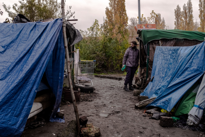 Un migrants au milieu de tentes dans un camp