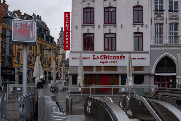 Façade d'un restaurant fermé, escalier roulant du métro en premier plan.