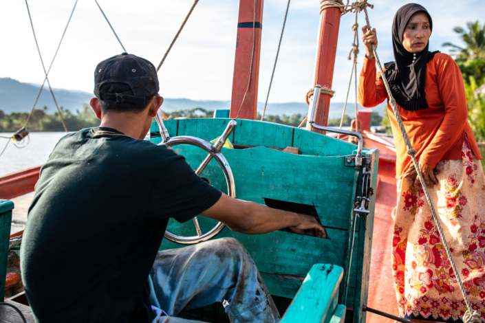 Une Cambodgienne et son mari sur un bateau de pêche. Les couleurs de la photo sont vives