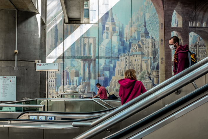 Photo prise dans le métro montrant un escalator et une fresque murale urbaine