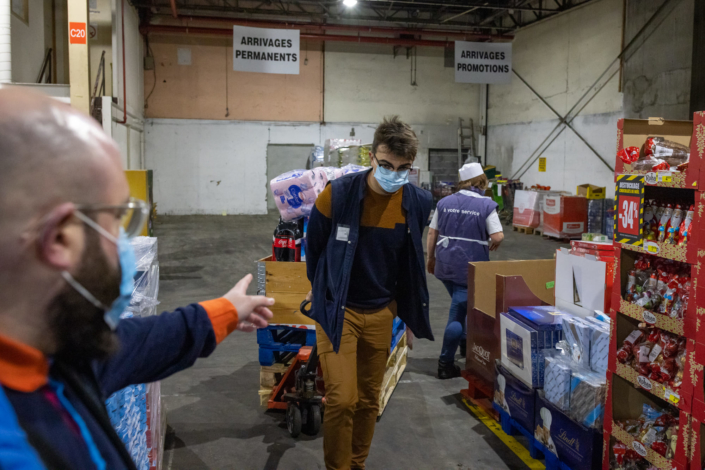 Un manutentionnaire transporte les denrées dans un hangar