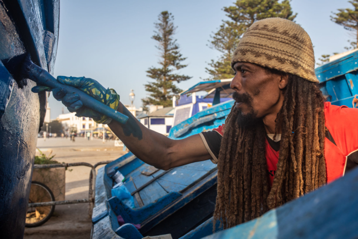 Un rasta peint un bateau