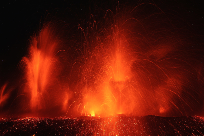 Gerbes de lave rouge dans la nuit