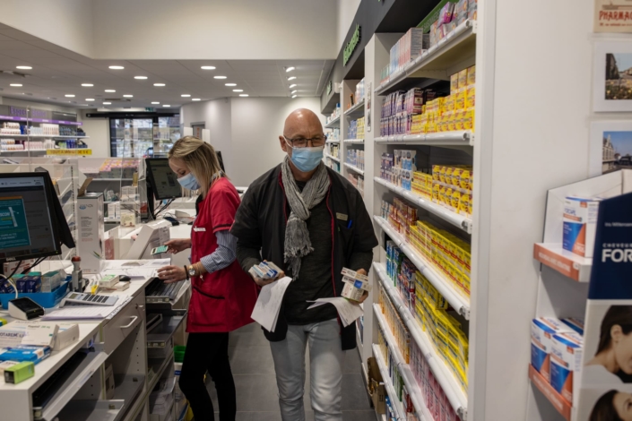 Deux pharmaciens travaillent derrière le comptoir.