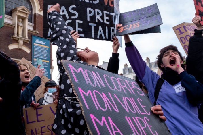 Gros plan sur trois femmes hurlant au milieu des pancartes