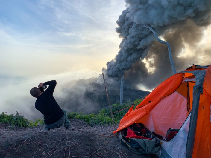 nuage de fumée sur un volcan. Campement au premier plan .