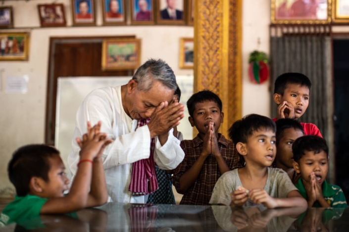 Un moine bouddhiste prie avec des enfants au cours du nouvel an chinois
