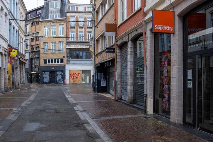 Rue déserte, façades de magazins fermés, les rideaux sont baissés