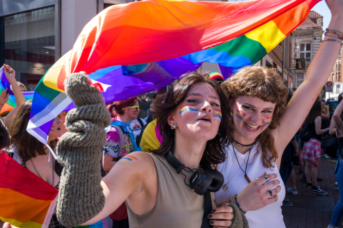 Photo de deux filles sous un drapeau aux couleurs de la fête de l'amour