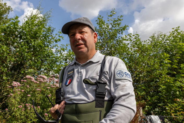 un policier de l'Office français de la biodiversité montre ses insignes de la police et de l'office français de la biodiversité