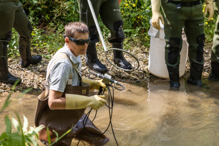 Une inspectrice tient des électrodes et des câbles électriques pour commencer une pêche