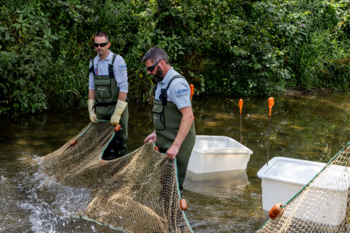 Deux agents rangent un filet de pêche