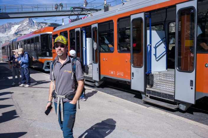 Un touriste devant un train sur le quai d'une gare de montagne en Suisse