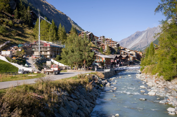 Torrent de montagne le long de chalets à flanc de coteau