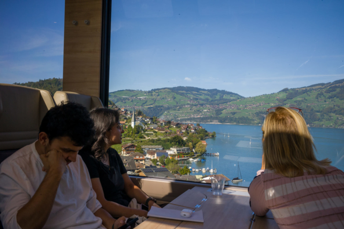 Touristes regardant un lac de montagne par la fenêtre d'un train