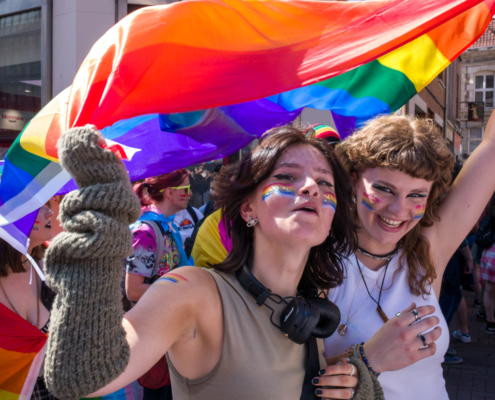 Photo de rue - La gay pride à lille, deux jeunes filles sous un drapeau