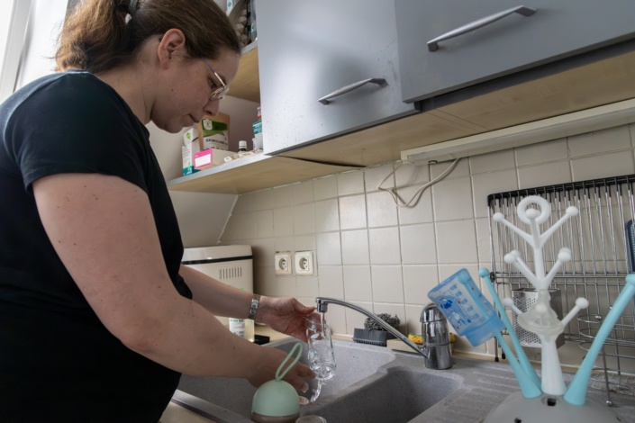 Maternité solo – Préparation bébé Nathalie enceinte prépare les biberons et accessoires de son futur bébé dans sa cuisine